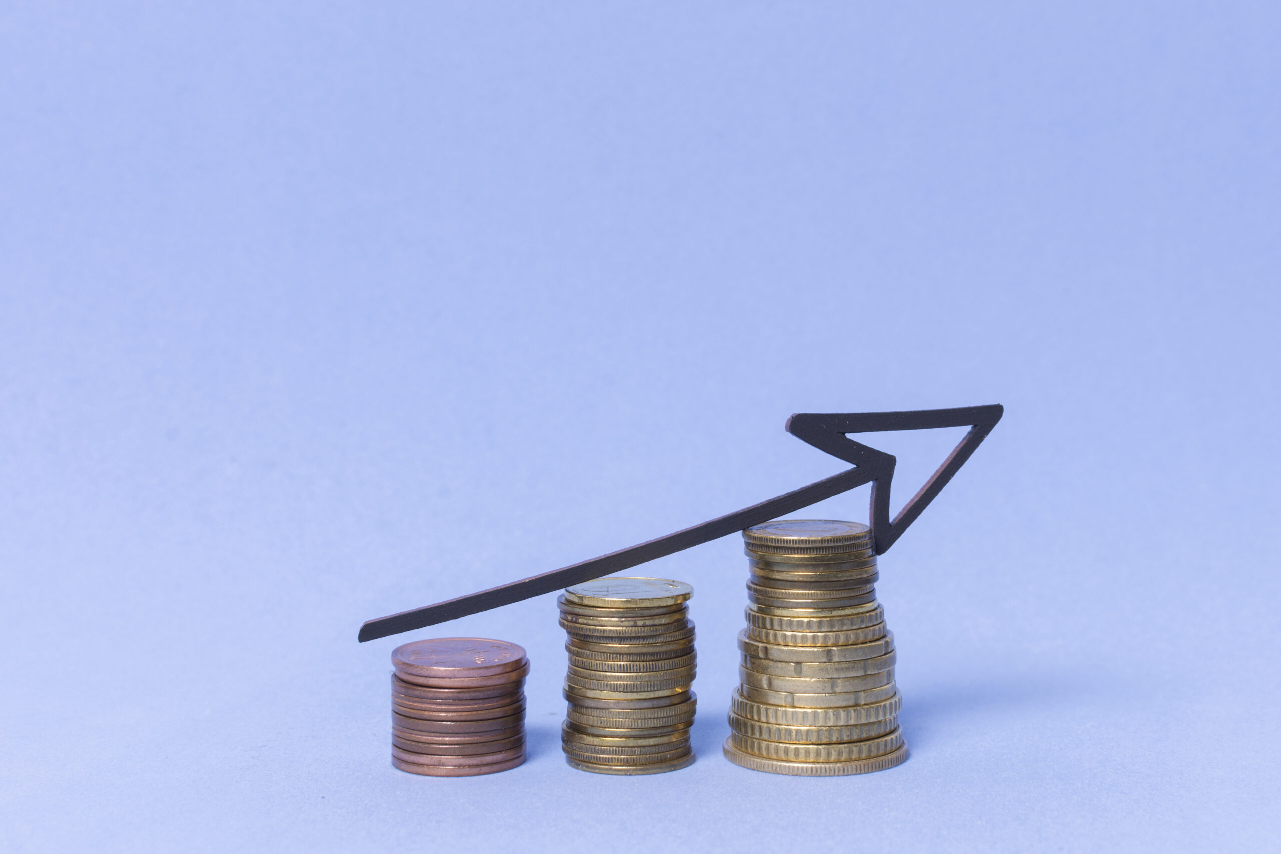 Flecha subiendo con pila de monedas